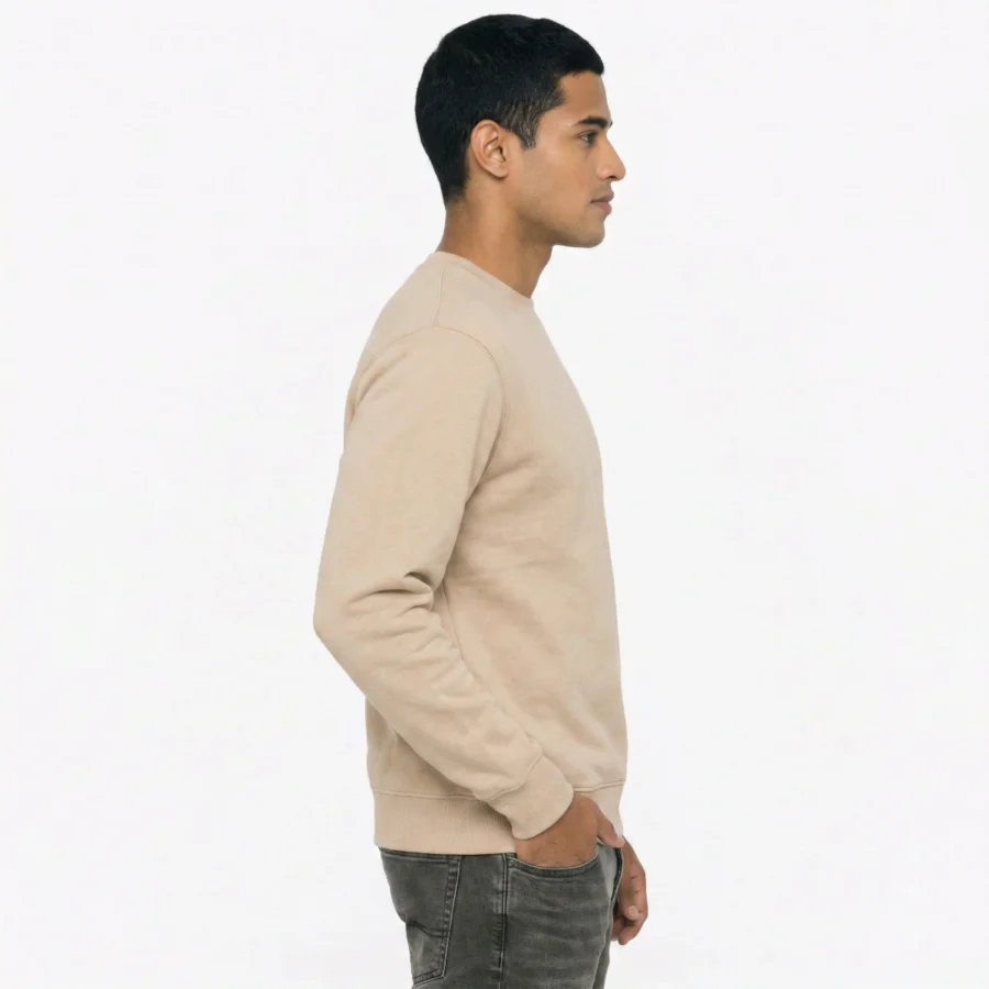 Man wearing a beige crew neck sweatshirt, side view, against a white background.