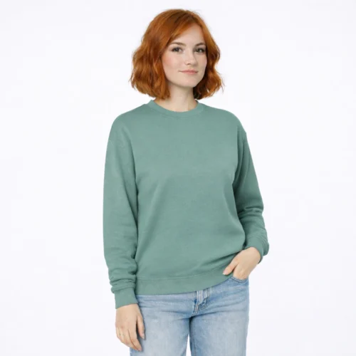 Mulher com cabelo ruivo a usar sweatshirt verde e jeans.