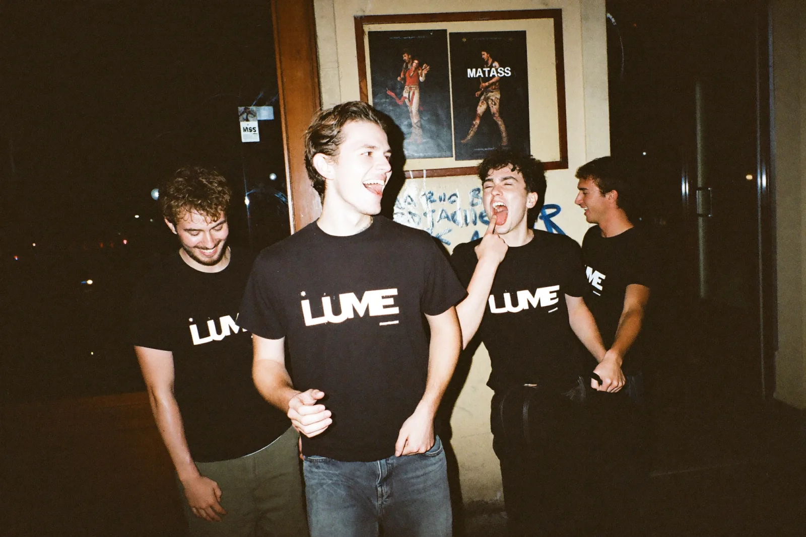 Merch para bandas: quatro músicos de t-shirt preta com o logótipo da banda, à porta da sala depois do concerto